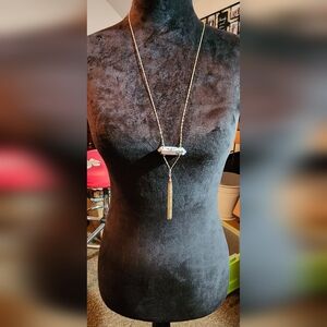 Gold necklace with tassel and white marble like pendant